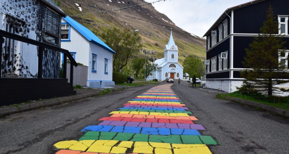 blue church and rainbow road in Seydisfjordur
